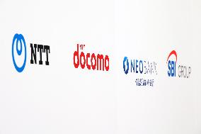 Signs and logos of NTT, NTT DoCoMo, SBI Sumishin Net Bank, and SBI Holdings